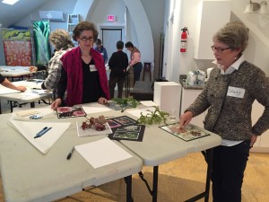 Sherry and Marilyn looking at objects from nature and printed inspiration.